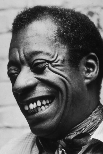 A Black man with a radiant smile in a grayscale photo
