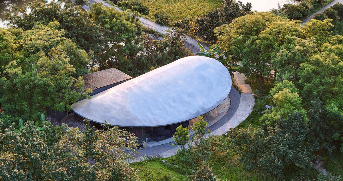 archermit sculpts ‘stone kiln in the valley’ with petal shaped roof